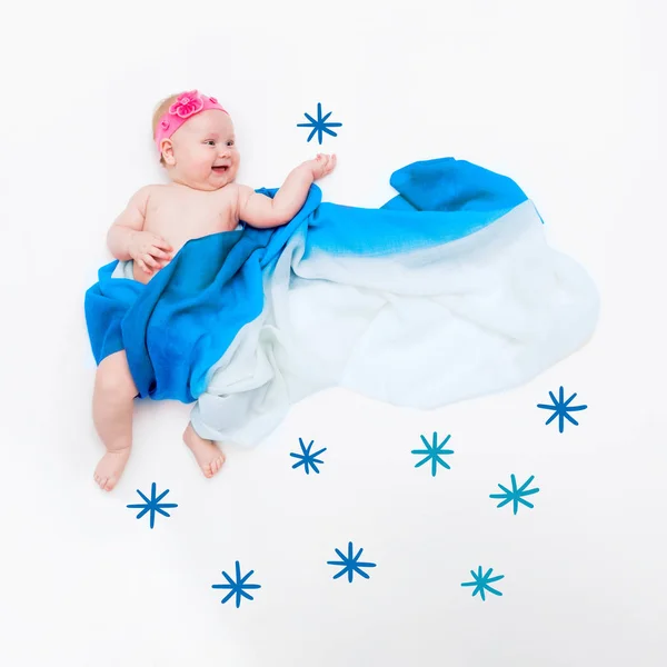 Vista superior de bebé lindo envuelto en una bufanda azul claro pone su mano para coger un copo de nieve — Foto de Stock