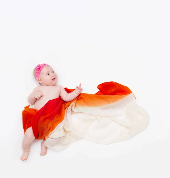 Top view of cute infant baby wrapped in a orange scarf pointing up — Stock Photo, Image