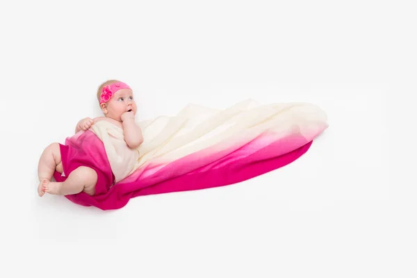 Niño acostado sobre fondo blanco envuelto en tela larga — Foto de Stock