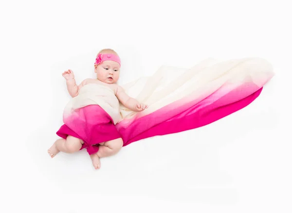 Niño acostado sobre fondo blanco envuelto en tela larga — Foto de Stock