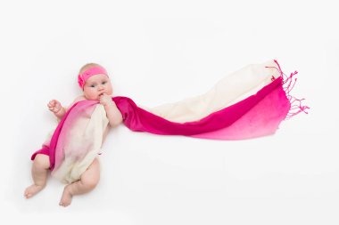 Uzun kumaşa sarılmış beyaz arka plan üzerinde yatan çocuk