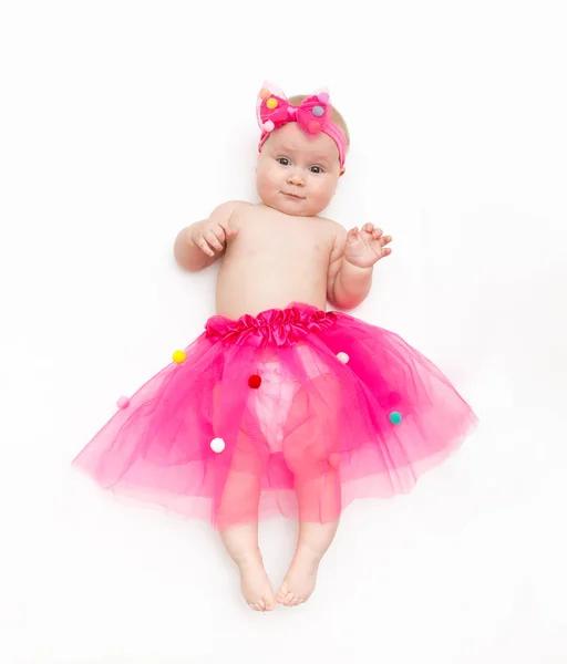 Retrato de un bebé dulce con un tutú rosa y un lazo de diadema, aislado en blanco — Foto de Stock