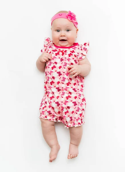 Portrait of a sweet infant baby girl wearing a pink dress and headband bow, isolated on white in studio — Stock Photo, Image