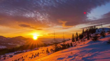 Kış dağ orman dramatik bulutlu gökyüzü arka plan üzerinde üzerinde gündoğumu. Timelapse.