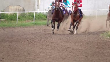 At yarışı. Toz ve kir yükselterek yarış pisti Jockeys atlarla. Yakın çekim. Ağır çekim.