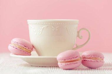 pembe macaron ev yapımı ve pembe bir arka plan üzerinde kahve tonlu