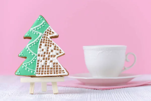 Christmas tree cookie with a cup of coffee on pink bakcground — Stock Photo, Image