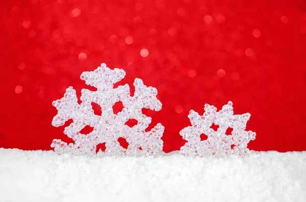 Christmas card with snowflakes in snow on red background with bokeh — Stock Photo, Image