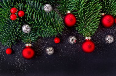 köknar ağacı dalı, kırmızı sapılmak ve siyah arka plan üzerinde baubles ile Noel dekorasyon