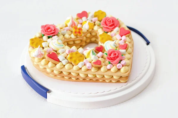 Narozeninový dort jako srdce s různými bonbóny — Stock fotografie