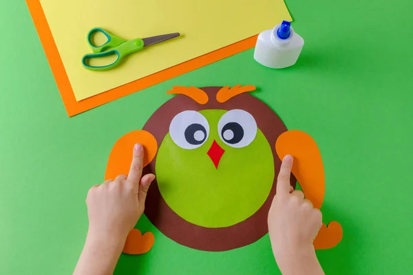 Çocuk bir baykuş renkli kağıt, tutkal ve makas ile yapıyor — Stok fotoğraf