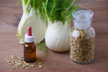 rezene esans, ampul ve koyu ahşap arka plan üzerinde tohum