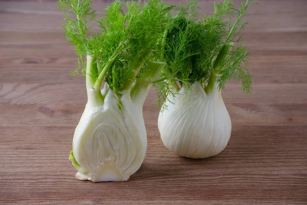 fresh fennel bulb and a half on wooden background