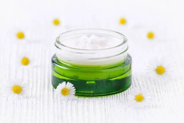 Натуральний крем з ромашкою в зеленій скляній банці — стокове фото