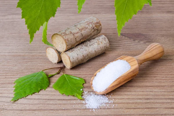 Sugar substitute xylitol, scoop with birch sugar, liefs and wood — Stock Photo, Image