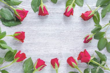 kırmızı gül ve ahşap arka plan, üstten görünüm üzerinde yeşil yaprak çerçeve çiçek