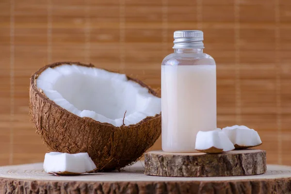 Bouteille cosmétique et noix de coco bio fraîche, fond naturel — Photo