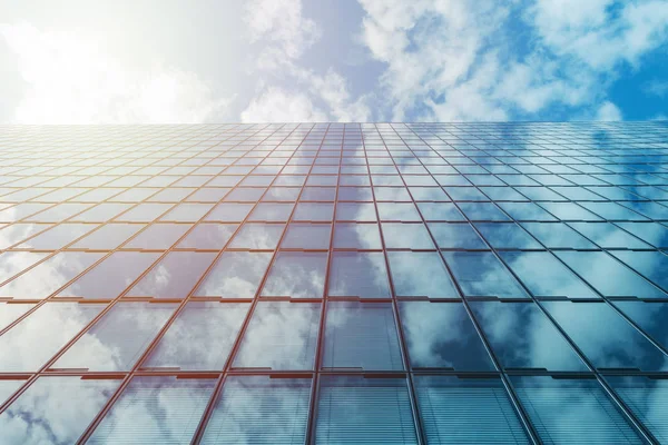 Moderno negocio edificio de vidrio de gran altura y cielo azul con nubes y sol — Foto de Stock