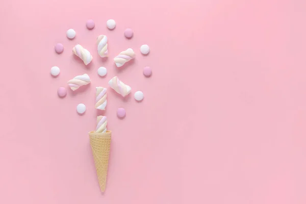 Bonbons, guimauve et crème glacée cône de gaufre sur fond rose, image concept — Photo