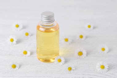 Taze papatya çiçeği, seçici odak, yüz ve vücut bakımı kozmetik bir şişeyle