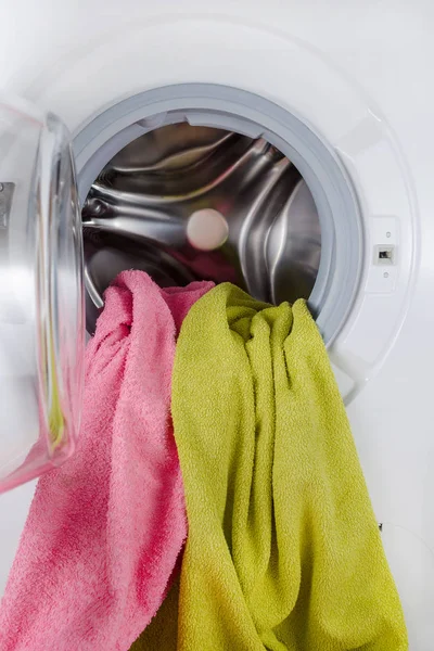 Стиральная машина с цветными полотенцами, одеждой, открытый — стоковое фото
