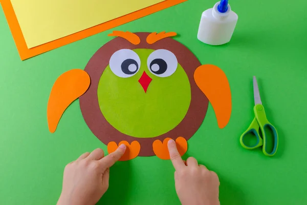 Kid is making a owl with color paper, glue and scissors — Stock Photo, Image