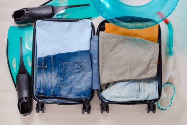 açık seyahat bavul giysi ve palet ve şnorkel maskesi bir gezi için üstten görünüm