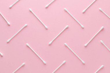 Pembe arka planda beyaz pamuklu çubuklar, soyut desen