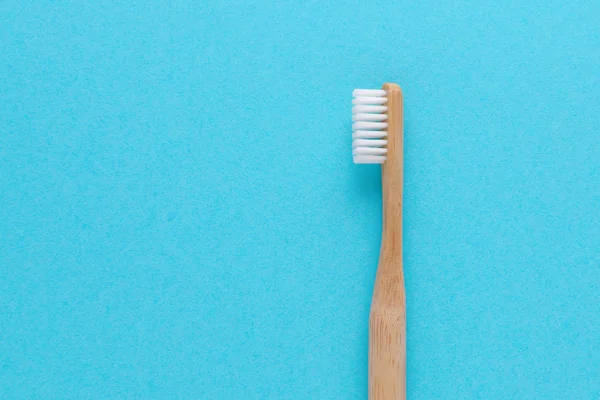 Деревянная зубная щетка на синем фоне с копировальным пространством — стоковое фото
