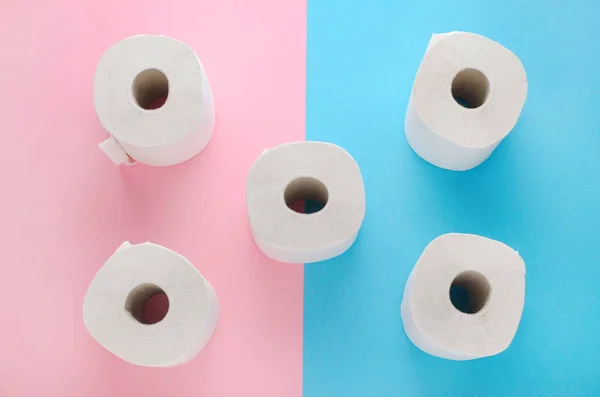 Rollos de papel higiénico blanco sobre fondo rosa y azul —  Fotos de Stock