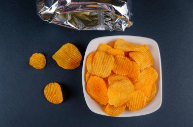 bir çanta ile bir kase içinde lezzetli altın kırmızı biber cips, düz yatıyordu