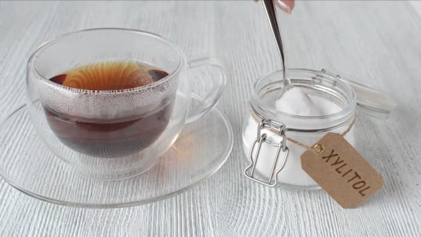 Junge Frau steckt Zuckerersatz Xylit in eine Tasse Tee, Nahaufnahme — Stockvideo