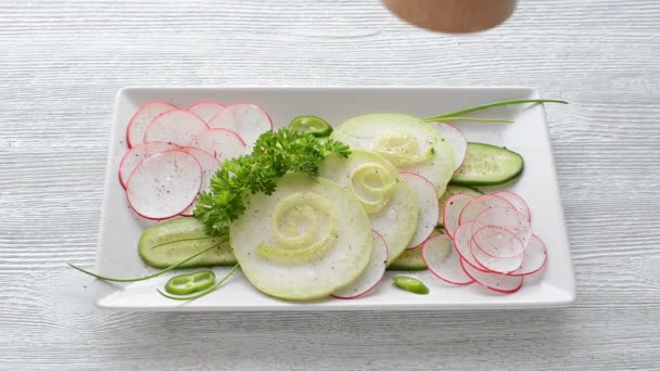 Light healthy salad with cucumber, radish, parsley and pepper on wooden table — Stock Video