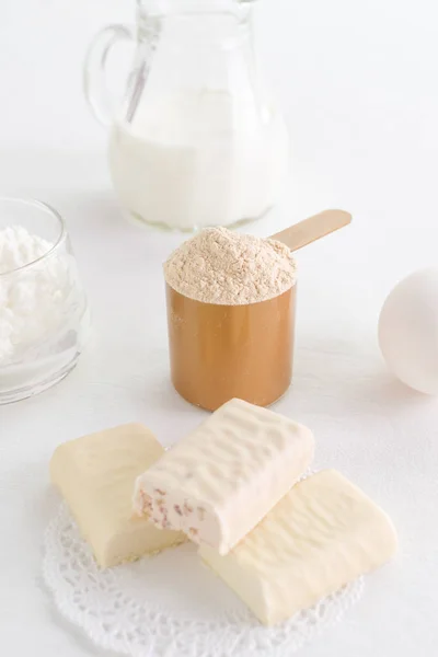 protein products such as whey powder, snack bar and egg with milk and curd, selective focus