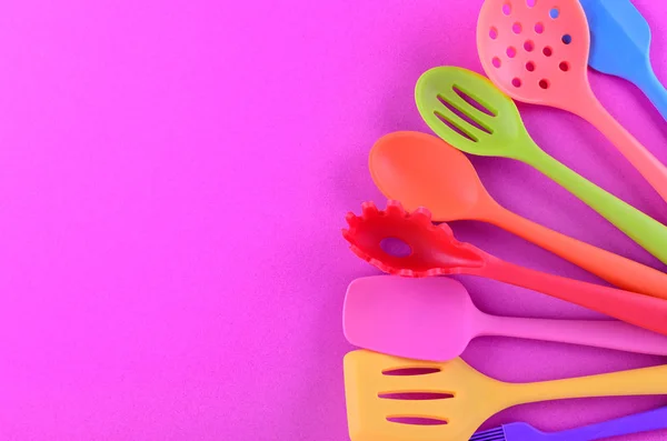 Φωτεινά πολυχρωματισμένα σκεύη κουζίνας σε μωβ φόντο με χώρο αντιγραφής — Φωτογραφία Αρχείου