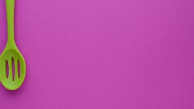 mor arka plan üzerinde parlak çok renkli mutfak gereçleri