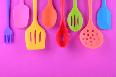 kopya alanı ile mor arka plan üzerinde parlak çok renkli mutfak gereçleri