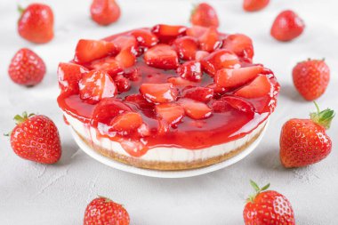 Çilekli cheesecake ve gri masada taze böğürtlen.