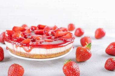 Çilekli cheesecake ve gri masada taze böğürtlen ve beyaz arka plan