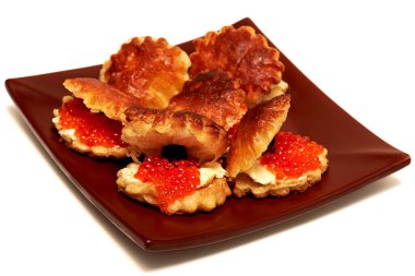 Beyaz arka planda kırmızı havyarlı, tereyağlı ve zeytinli atıştırmalıklar.