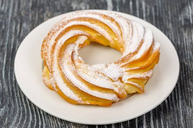 Şeker tozu ve kremalı halka şeklinde ekler.