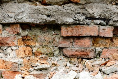 Çok eski bir tuğla, kırmızı-turuncu ve kahverengiyle kaplı yıkım duvarı. Doku
