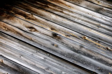 Binanın yüzeyinin dokusu gri ve kahverengi eski ahşap tahtalardan yapılmıştır. Yatay, dikey ve çapraz tahtalar