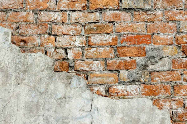 Çok eski bir tuğla, kırmızı-turuncu ve kahverengiyle kaplı yıkım duvarı. Doku