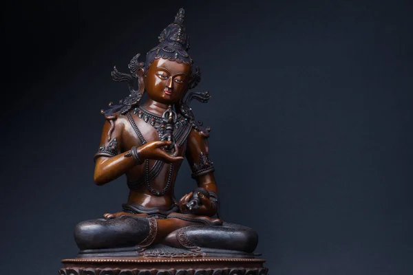 Vajrasattva'nın heykel bir elinde bir dorje ve siyah arka plan üzerine başka bir el çan ile oturuyor. Vajrasattva - Buda Samantabhadra gizli bir tür.