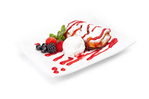 香草冰淇淋球和在白色盘子上加糖衣的蛋糕 由黑莓 草莓和越橘的浆果装饰 用覆盆子果酱浇水 它被隔离在白色背景上 — 图库照片