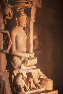Kırmızı kumtaşı Khajuraho Tapınakları birinde yapılan bir meditasyon poz oturan Jain antik heykeli.