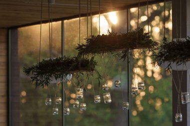 Şeffaf cam kavanoz ve çiçekler, asılı için uzun ahşap kutularda süs bitkileri Restoran kirişler ışık gün batımının çerçevede Ziyafet odasında bir tavan askıya.