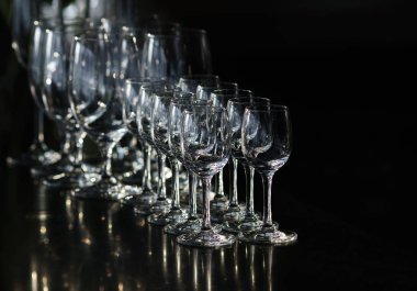 Satır boş kadehlerin ve boş bardak votka, unsharpness için gidiş için siyah bir arka plan üzerinde duruyor. 