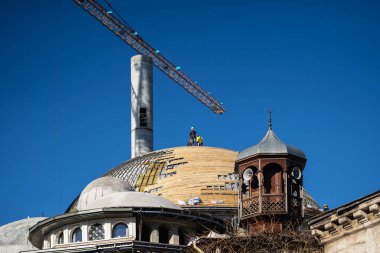 Eski bir ahşap Minare arka planı büyük modern cami inşaatı var. Üzerinde 17 Ocak 2019, Türkiye, Istanbul, Taksim Meydanı.